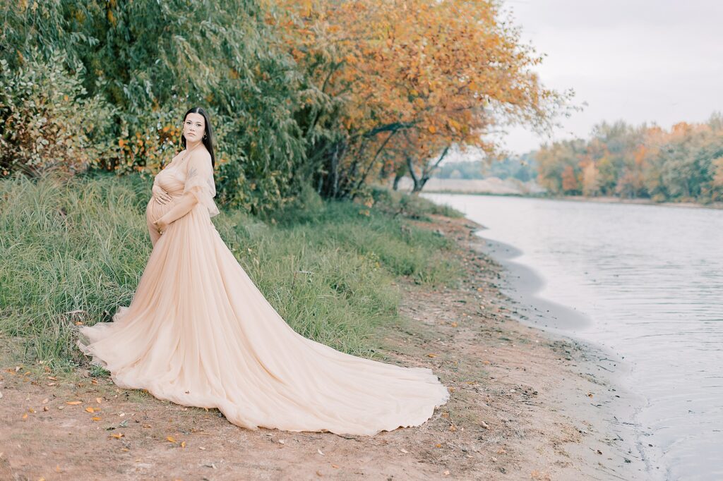 Abigail on the shoreline with autumn foliage